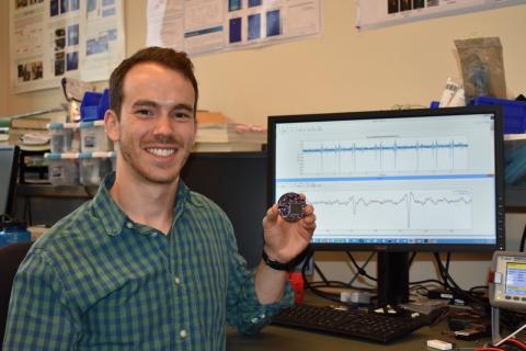 Yang Research Award recipient James Rosenthal holds a NeuroDisc prototype, which he developed at the UW Department of Electrical & Computer Engineering in the lab of CNT member Matt Reynolds. The NeuroDisc is a low-power wireless brain-computer interface intended for use in electrophysiology experiments. Photo courtesy of Matt Reynolds James Rosenthal holding NeuroDisc prototype