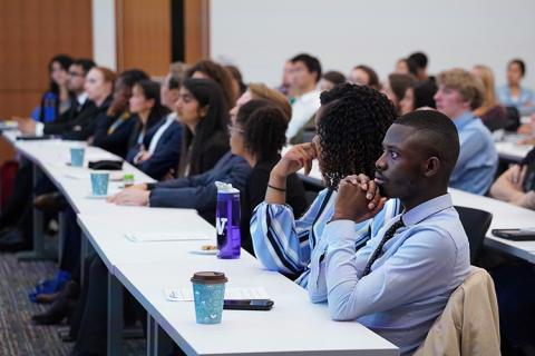 A group of students in a class or event listening to a speaker