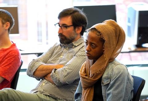 A man and young, female student listening at the roundtable
