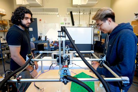UW Undergraduate Fellow, Usman Khan (left), worked side-by-side over the summer with REU participant, Tri Nguyen (right), in the UW Sensor Systems Laboratory. Their research projects involved using machine-learning techniques to map magnetic fields, which is related to accomplishing wireless power and data transfer needed for neural implants the CNT is developing. Two men working on a project together in a lab
