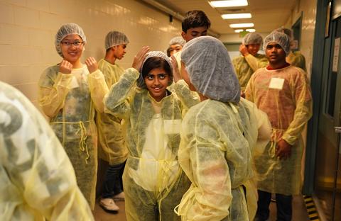 Students putting on sterile clothing coverings.