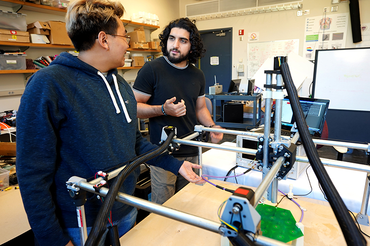 Two men talking and working on a large engineering device